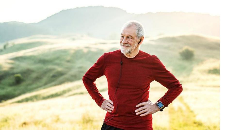 Older man working out Older man standing outside with hands on his hips